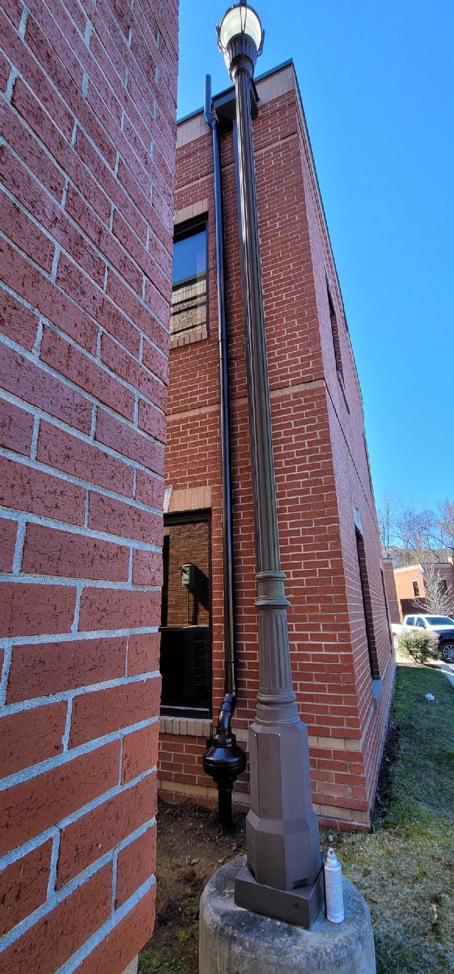 Radon mitigation system installed on a brick building exterior